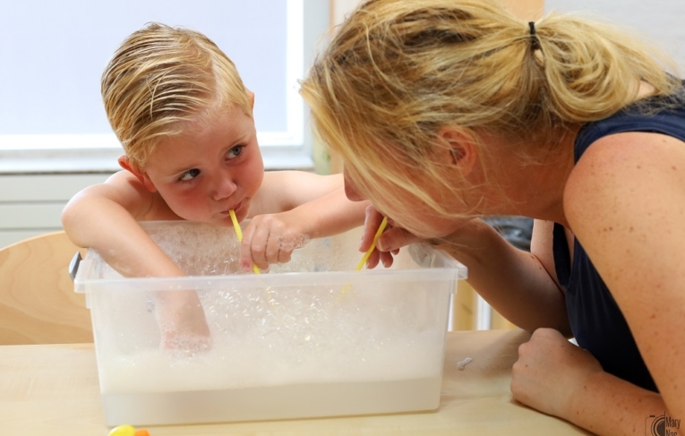 Medewerker met kind en zeepsop